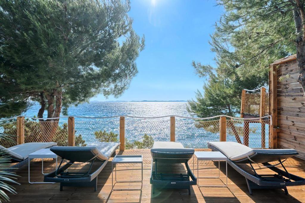 a deck with chairs and a view of the water at Loli in Jezera