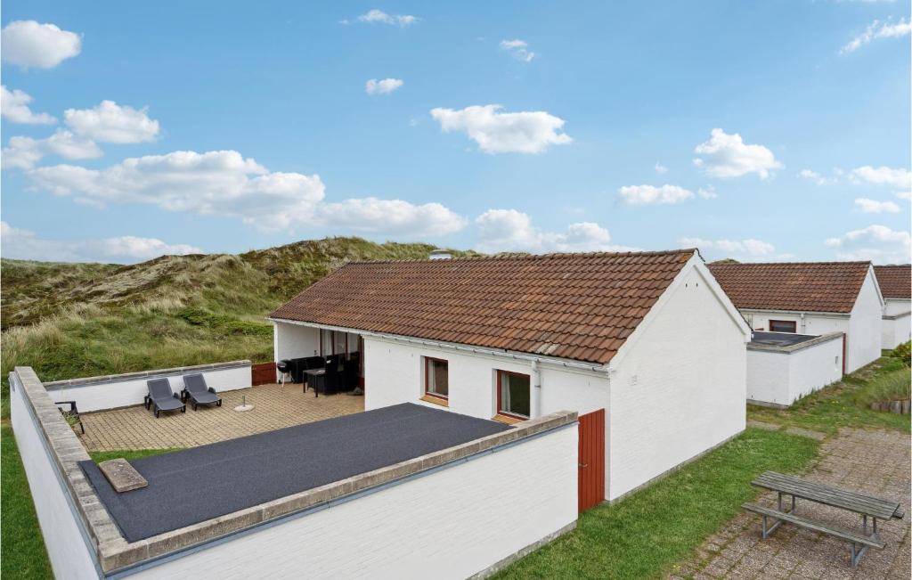 a white house with a deck and a patio at Awesome Home In Pandrup With Kitchen in Rødhus