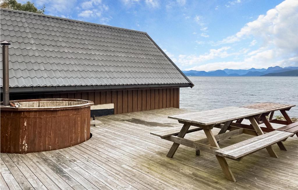 two picnic tables on a deck next to a hot tub at Nice Home In Midsund With Kitchen in Midsund