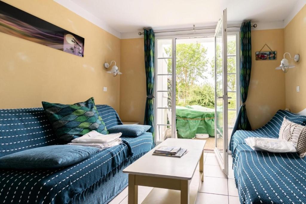 un salon avec deux canapés bleus et une table dans l'établissement Les Maisons de Port Bourgenay - maeva Home - Maison 2 pièces 5 personnes - Sélection MAE-3924, à Talmont-Saint-Hilaire