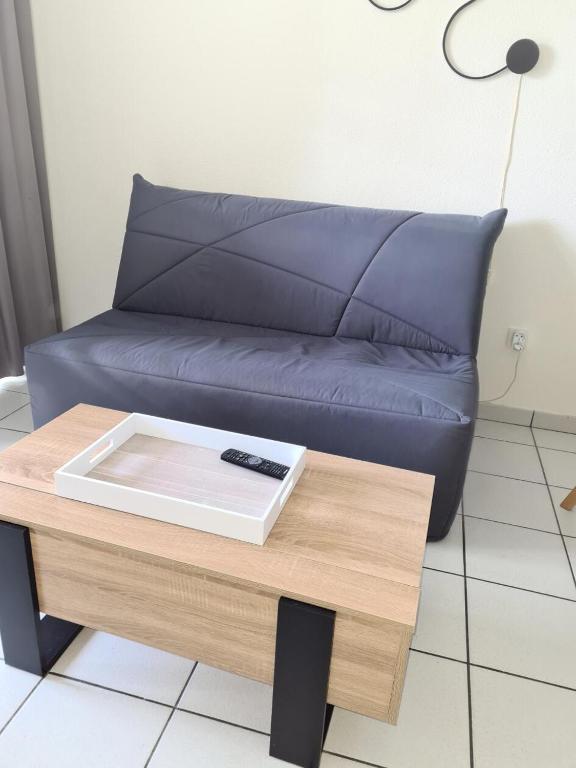 un salon avec un canapé bleu et une table dans l'établissement Résidence Port Bourgenay - maeva Home - Studio 4 Personnes - Sélection MAE-5584, à Talmont-Saint-Hilaire