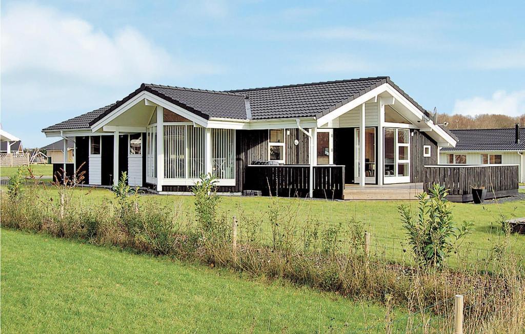 SønderbyにあるNice Home In Juelsminde With 4 Bedrooms, Sauna And Wifiの前の緑の芝生の家