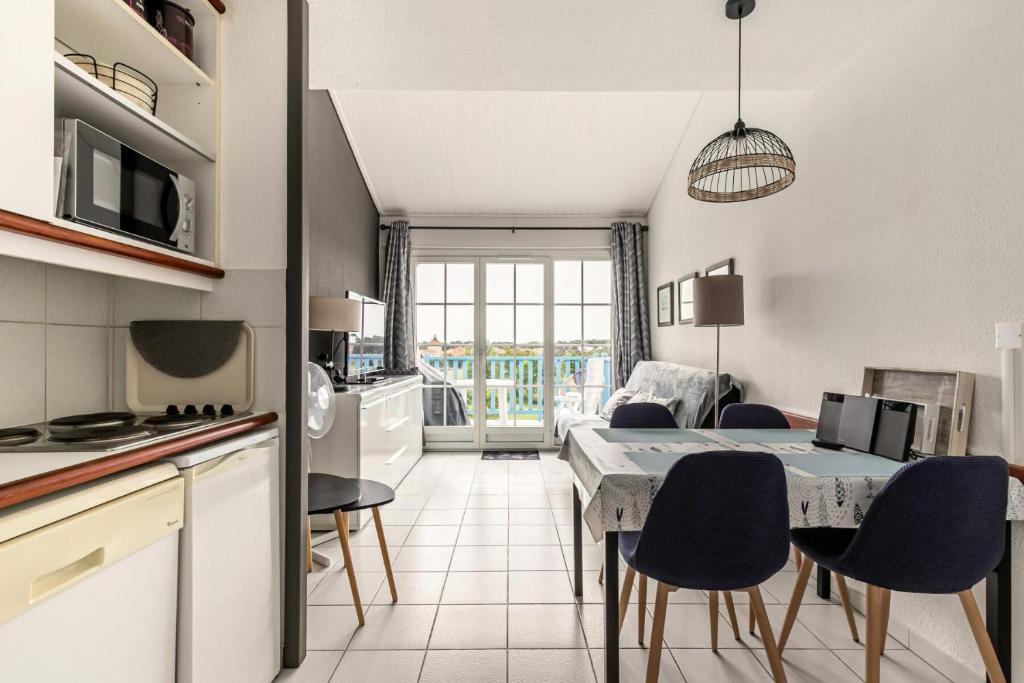 une cuisine et une salle à manger avec une table et des chaises dans l'établissement Résidence Port Bourgenay - maeva Home - Appartement 2 pièces 4 personnes - Sélection MAE-2244, à Talmont-Saint-Hilaire