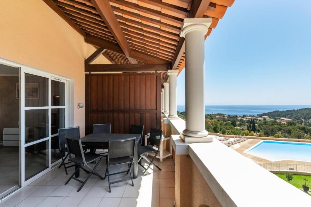 un patio avec une table et des chaises sur un balcon dans l'établissement Résidence le Hameau de Cap Esterel - maeva Home - Appartement 3 pièces 6 personnes - Prestige MAE-1574, à Saint-Raphaël