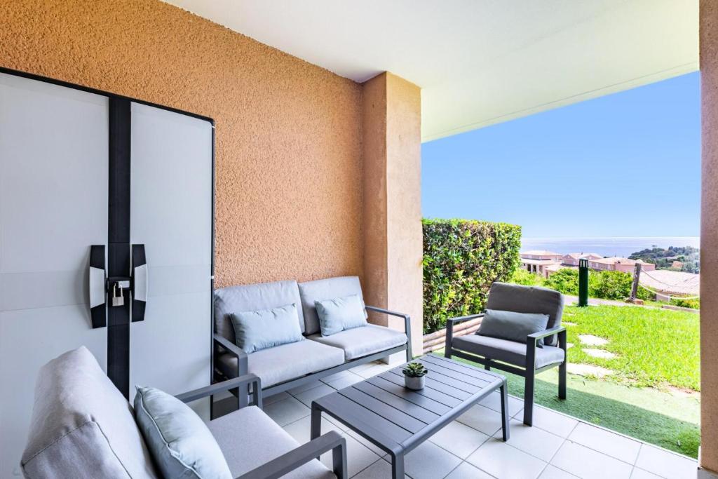 d'une terrasse avec un canapé, des chaises et une table. dans l'établissement Résidence le Village de Cap Esterel - maeva Home - Appartement moderne 2 pièces 4 personnes - Prestige - super Home MAE-4494, à Saint-Raphaël