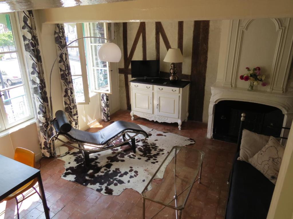 a living room with a chair and a fireplace at Appartement Le Notre Dame in Honfleur