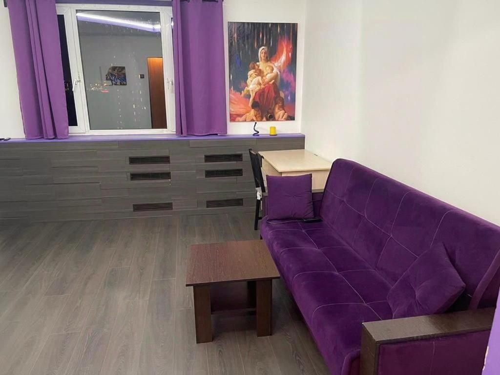 a living room with a purple couch and a table at Janis poils home 1 in Ventspils