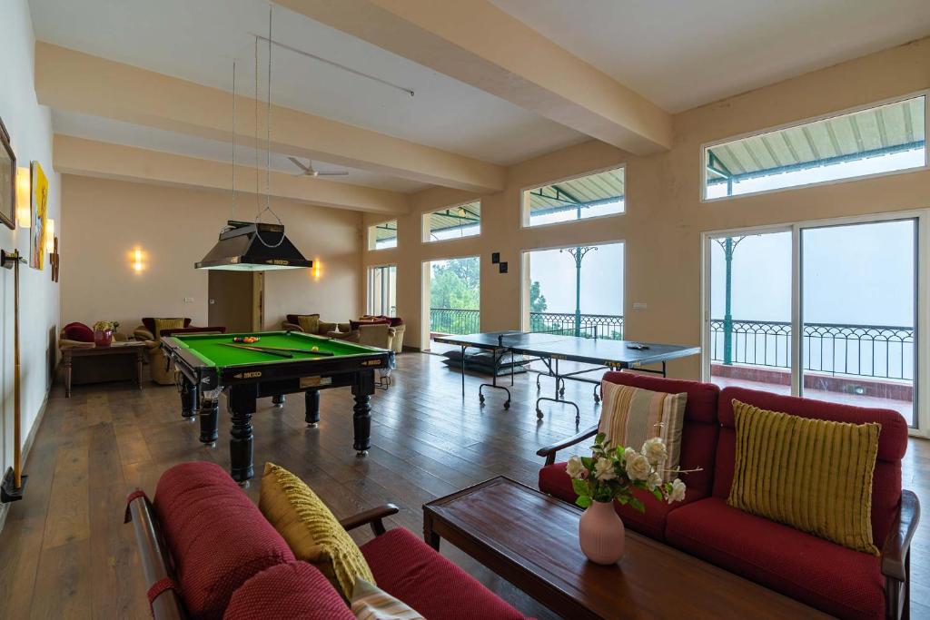a living room with a pool table and ping pong at StayVista at Ludlow House Luxury 4BHK Valley View villa in Kasauli with Sauna room in Kasauli