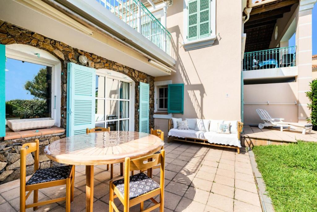 un patio avec une table, des chaises et un canapé dans l'établissement Résidence le Village de Cap Esterel - maeva Home - Appartement 2 pièces 6 personnes - Sélection MAE-8594, à Saint-Raphaël
