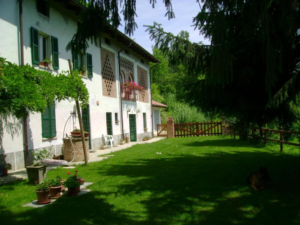 un patio frente a una casa blanca con persianas verdes en B&B Locanda della Sesta Felicità, en Vaglio Serra
