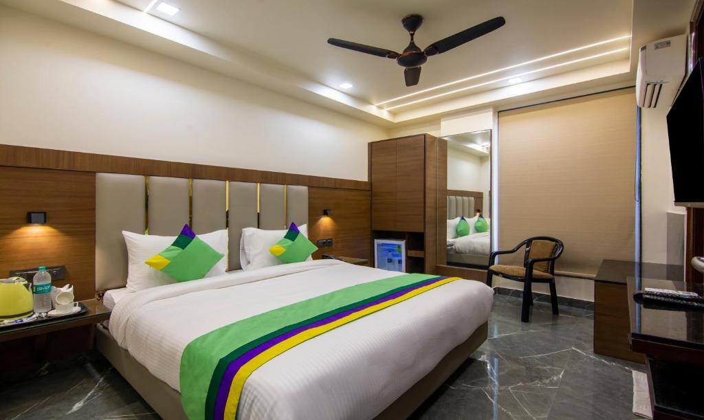 1 dormitorio con 1 cama grande con una manta colorida en Treebo Trend Royal Comfort, en Nueva Delhi