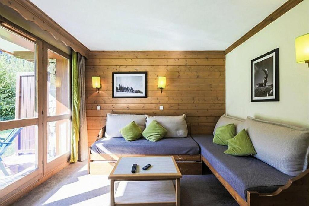 a room with two beds and a couch and a table at Quartier La Forêt - maeva Home - Appartement 2 pièces 6 personnes + coin cabine - Sélection MAE-1634 in Valmorel
