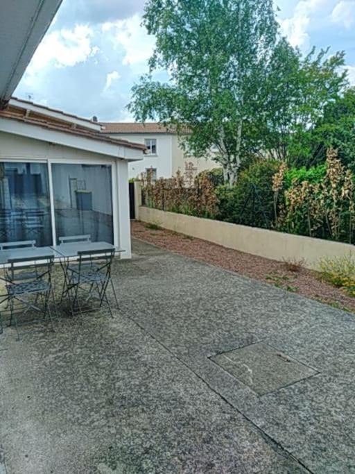 une table et des chaises assises à l'extérieur d'une maison dans l'établissement maison agréable avec stationnement privatif, à Angoulême