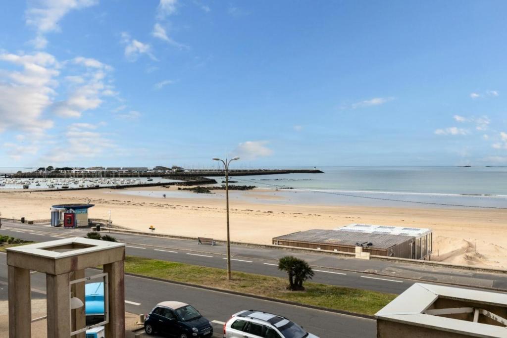 - une vue sur une plage avec des voitures garées sur la route dans l'établissement Résidence Les Océanes - maeva Home - Studio 5 personnes vue mer - Sélection MAE-9254, à Pornichet