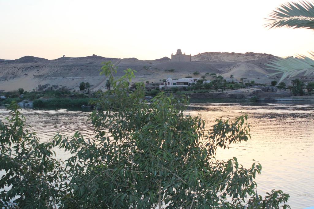 un corpo d'acqua con una casa in lontananza di Nile View (2) Guest House a Aswan