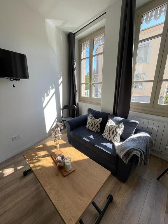 een woonkamer met een blauwe bank en een salontafel bij T1 Cocon proche du stade app 102 in Saint-Étienne