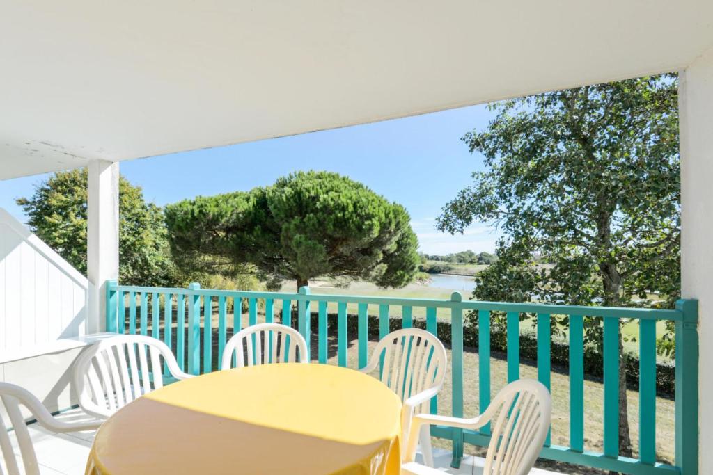 une table et des chaises jaunes sur un balcon avec vue sur l'eau dans l'établissement Résidence Port Bourgenay - maeva Home - Appartement Sélection 2 pièces 4 personnes MAE-3583, à Talmont-Saint-Hilaire