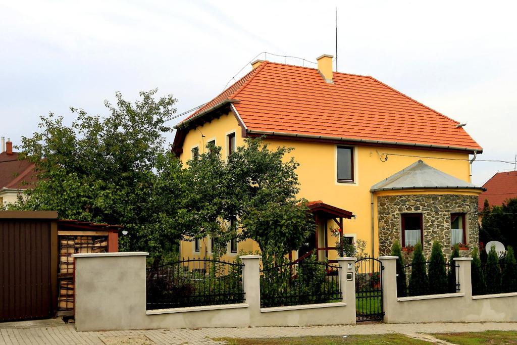 a yellow house with a fence in front of it at Nemes Apartman in Eger