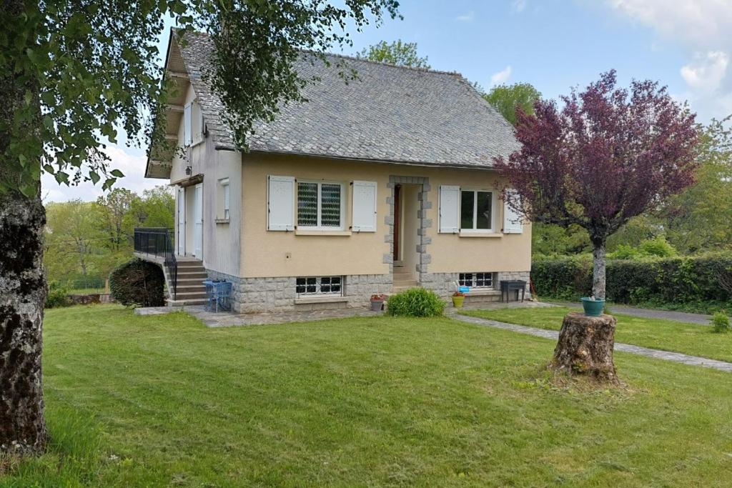 a white house with a tree in the yard at La Maison des 3 Bouleaux in Lafeuillade-en-Vézie
