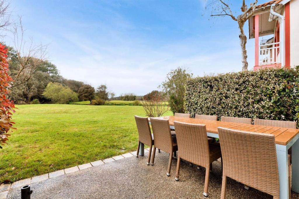 d'une table et de chaises avec vue sur un champ dans l'établissement Les Maisons de Port Bourgenay - maeva Home - Maison cosy 3 pièces 8 personnes - Prestige - super Home MAE-7094, à Talmont-Saint-Hilaire