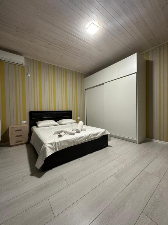 a bedroom with a bed and a large white screen at Guesthouse Chrdili in Tbilisi City