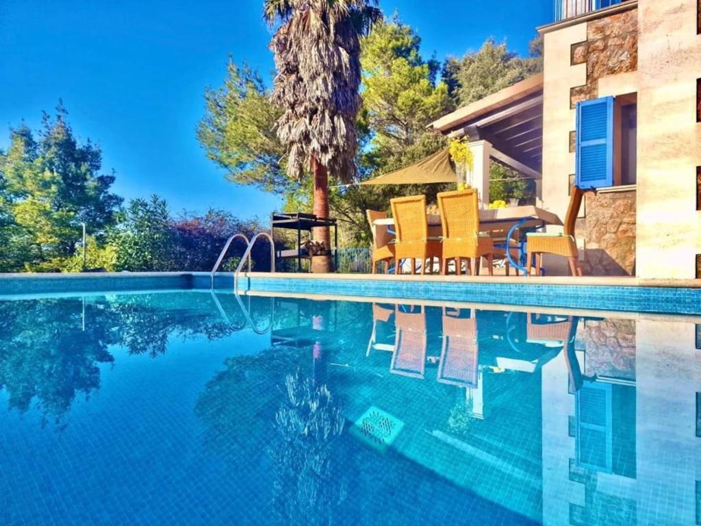 a swimming pool with chairs next to a house at VILLA SOFIA in Valldemossa