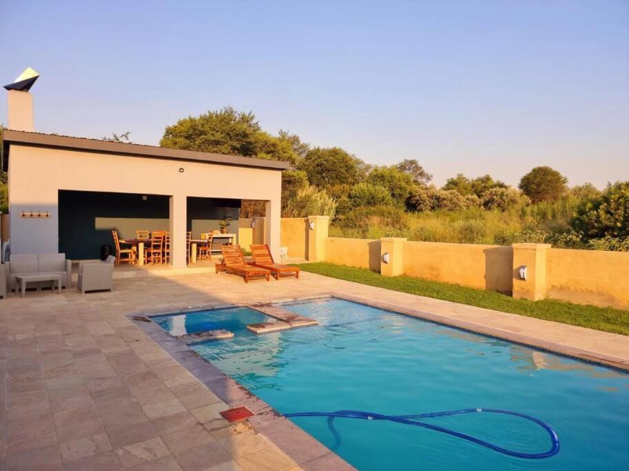 a swimming pool in front of a house at 391 Vaal de Grace Golf Estate, Parys in Parys