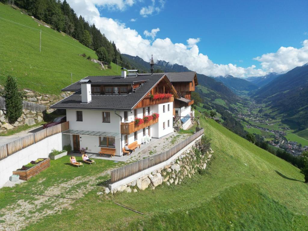 a house on the side of a hill at Ortnerhof in San Giovanni in Val Aurina
