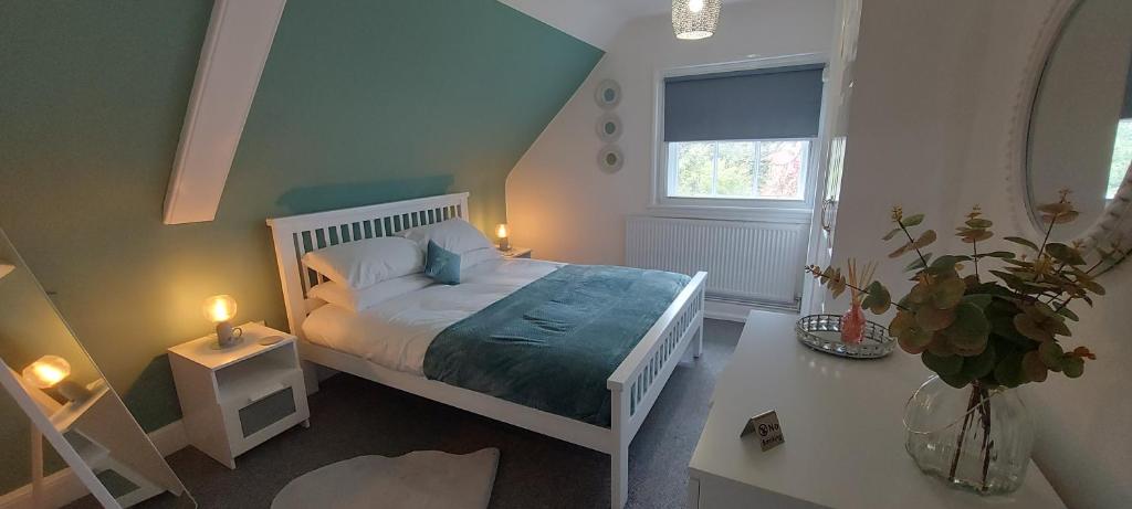a bedroom with a white bed and a window at Gilpin Suite in Cannock