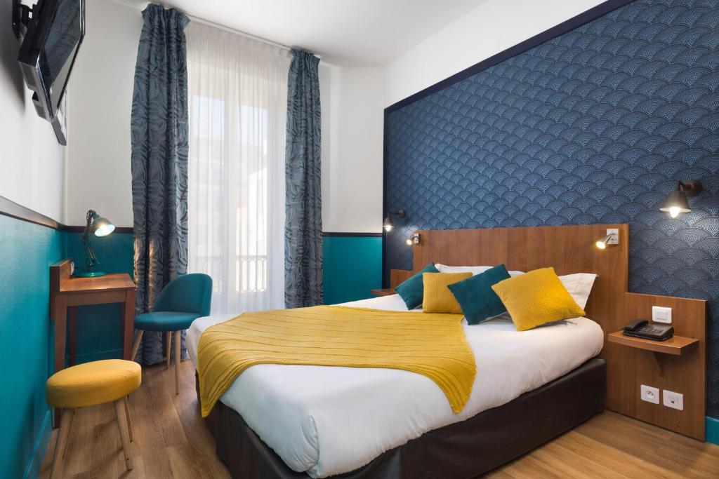 sypialnia z dużym łóżkiem i niebieską ścianą w obiekcie Hotel Nap By HappyCulture w Nicei