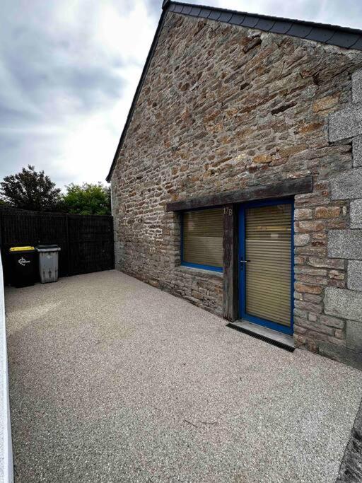 - un bâtiment en briques avec deux portes de garage dans l'établissement Maison chez Emilie, à Trégunc