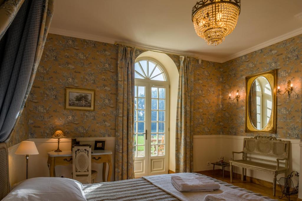 un dormitorio con una cama y una ventana en L'Orangerie du Grand Jardin, en Condé-sur-Seulles