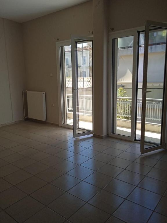 an empty room with doors and a tiled floor at COMFORT RENT in Lamía