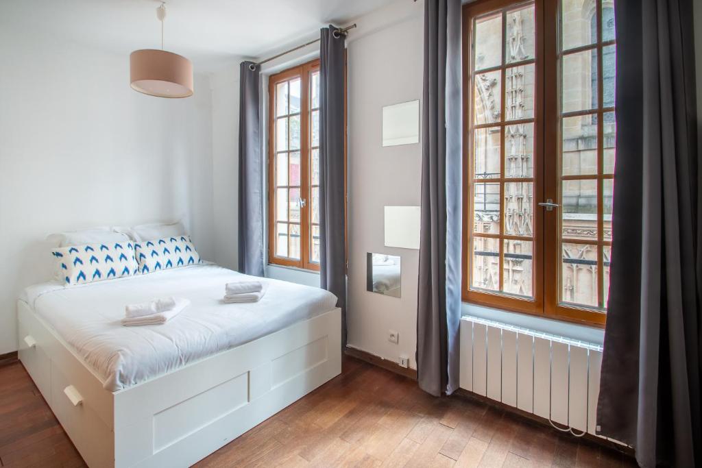 une chambre avec un lit et deux fenêtres dans l'établissement Studio au cœur du Marais, à Paris