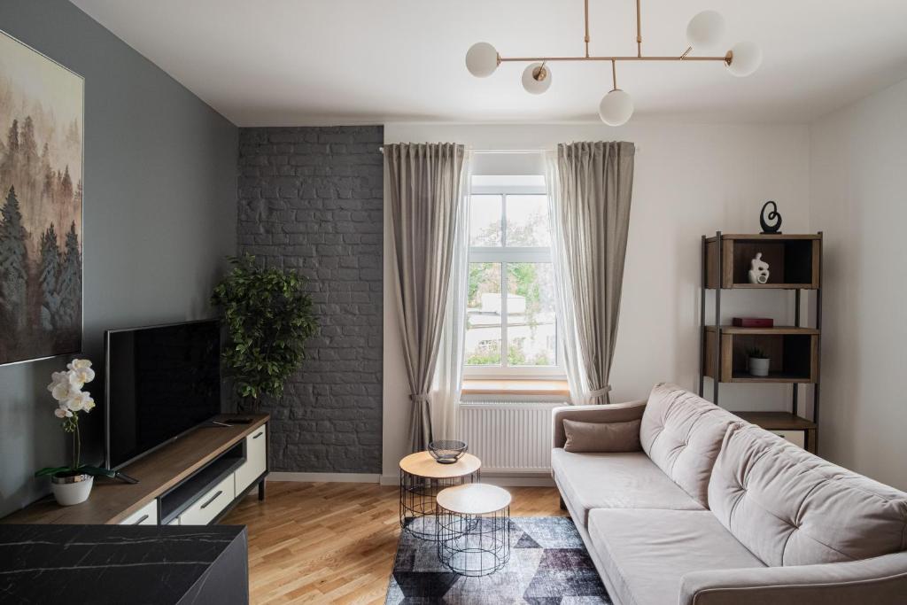 a living room with a couch and a tv at Homly S22 in Rīga