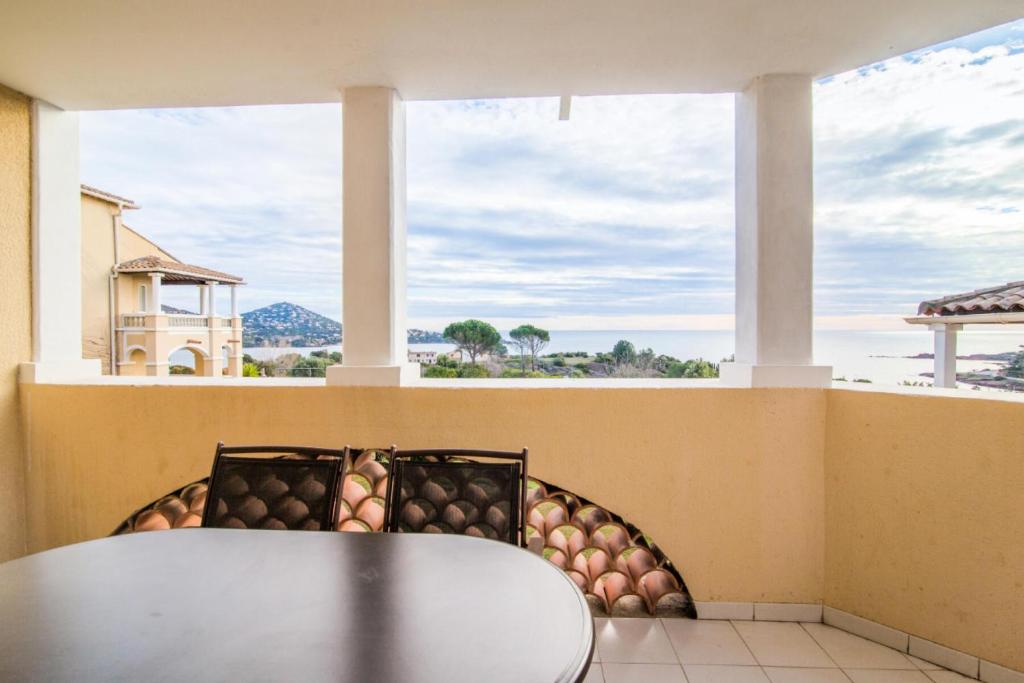 d'une table et de chaises sur un balcon avec une fenêtre. dans l'établissement Résidence le Village de Cap Esterel - maeva Home - Studio 4 personnes Sélection MAE-4480, à Saint-Raphaël