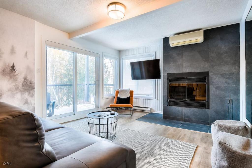 a living room with a couch and a fireplace at Fresh 1 Bdr in the Heart of Mile End by Denstays in Montréal