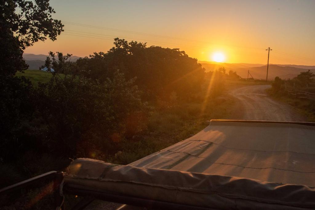 a truck driving down a dirt road at sunset at Louis at Magwa Falls in Lusikisiki