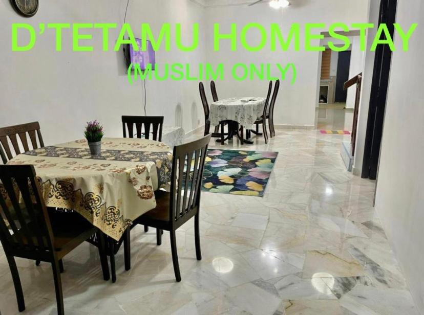 uma sala de jantar com uma mesa e cadeiras num piso de azulejo em D TETAMU Bandar Sg Long em Kajang