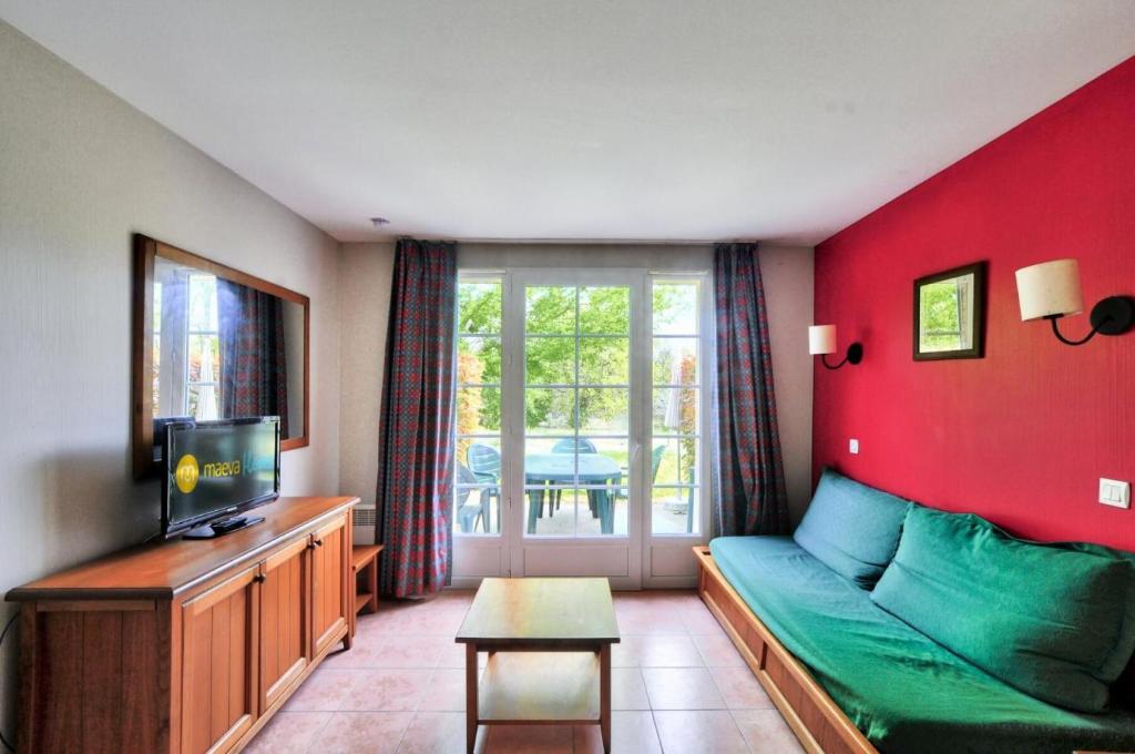 un salon avec un canapé et une télévision dans l'établissement La résidence du Lac - maeva Home - Maison 3 pièces 6 personnes - Sélection MAE-5604, à Monflanquin