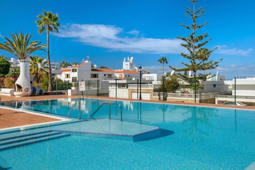 アデへにあるApartamento Costa Adejeの屋根にヤシの木がある大きなプール