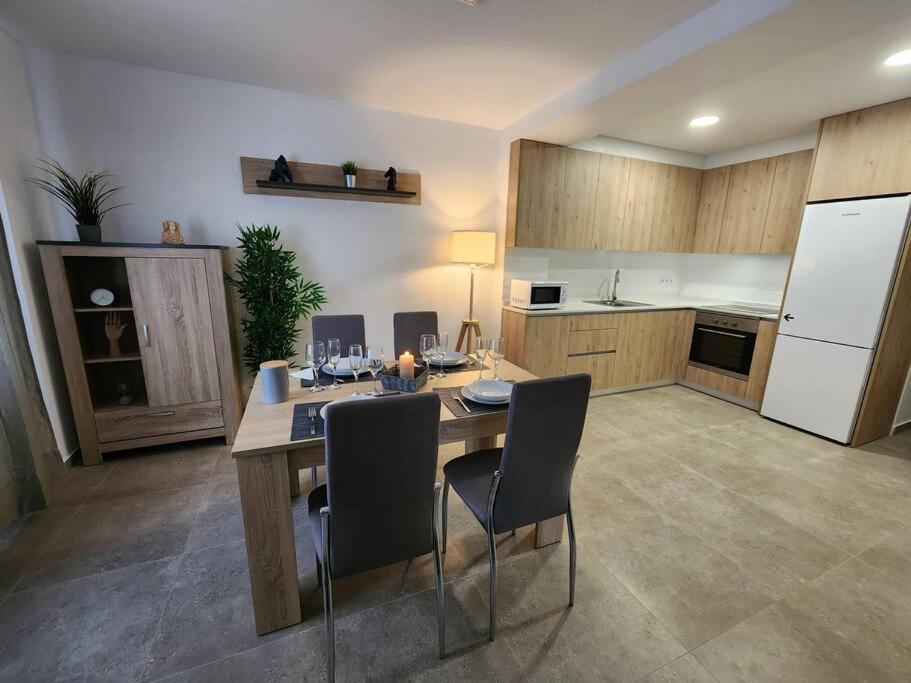 a kitchen with a table with chairs and a white refrigerator at Piso de diseño Elche in Elche