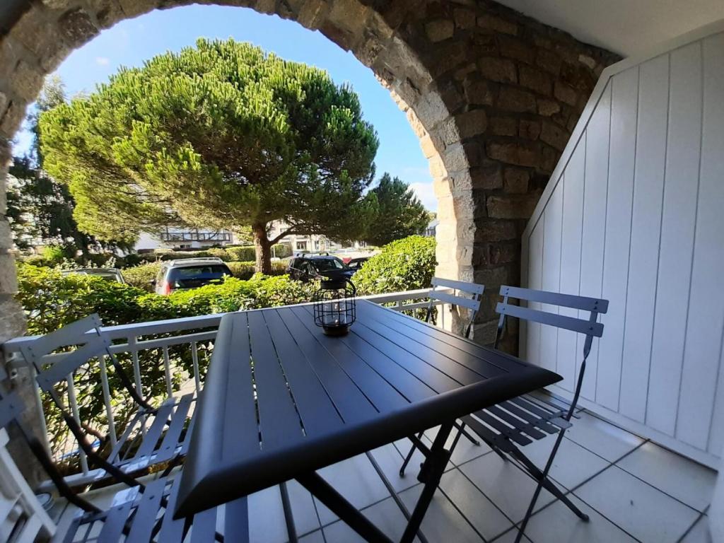 - une table de pique-nique noire sur un balcon avec un arbre dans l'établissement Résidence Port du Crouesty - maeva Home - Appartement 2 pièces 4 personnes - Confort MAE-5428, à Arzon
