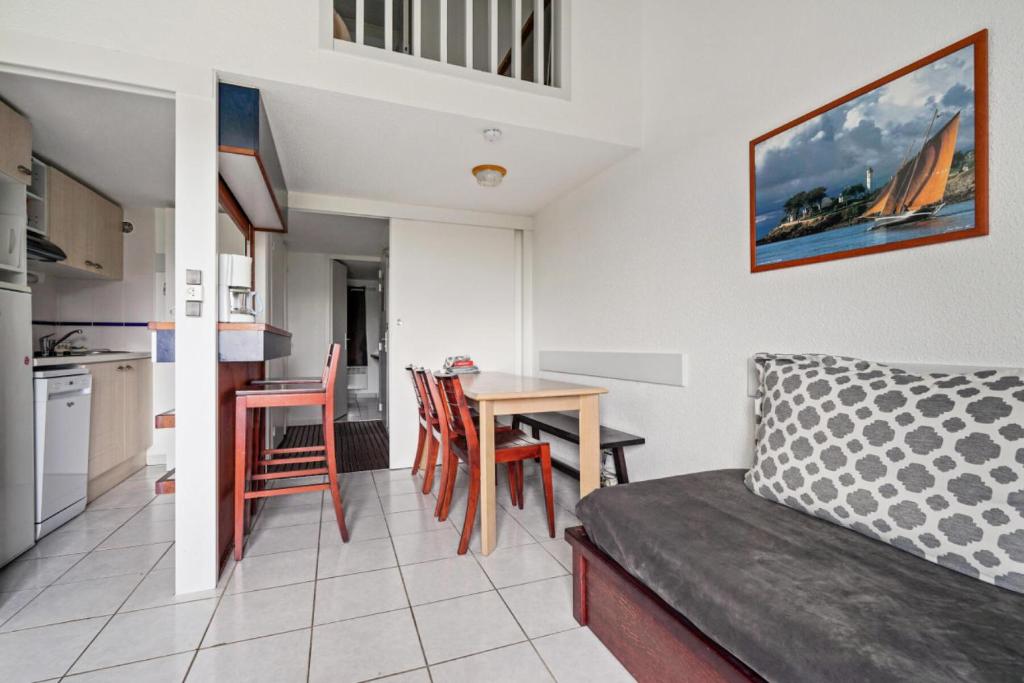 - un salon avec une cuisine et une table avec des chaises dans l'établissement Résidence Port du Crouesty - maeva Home - Appartement 2 pièces 7 personnes - Sélection MAE-7507, à Arzon