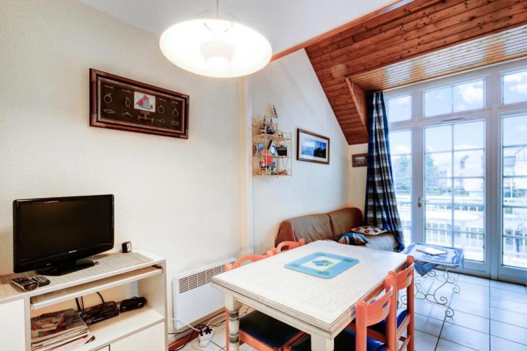 un salon avec une table et une télévision dans l'établissement Résidence Port du Crouesty - maeva Home - Appartement 3 pièces 5 personnes - Budget MAE-2144, à Arzon