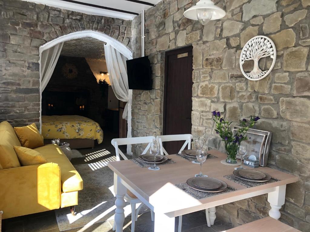 a living room with a table and a stone wall at Olli's Cottage-Terrace & Jacuzzi in Bristol