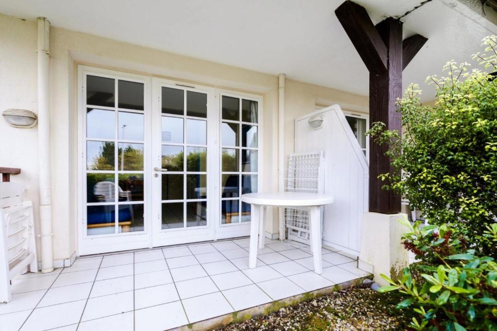 d'une terrasse avec une table blanche devant une fenêtre. dans l'établissement Résidence Port du Crouesty - maeva Home - Studio 5 Personnes - Confort MAE-5431, à Arzon