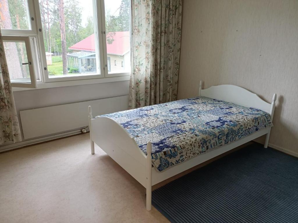 a bedroom with a bed in front of a window at Siisti valoisa kolmio in Lieksa
