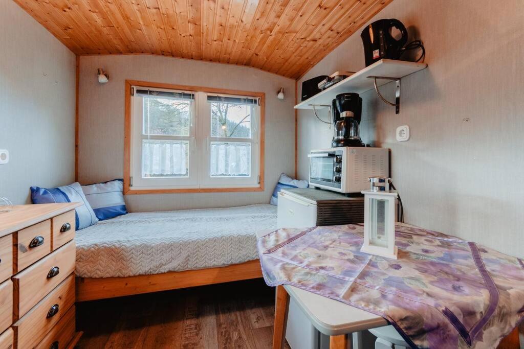 um pequeno quarto com uma cama e uma janela em Tinyhouse auf dem Sonnenhang em Osterode