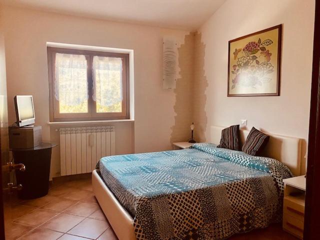 een slaapkamer met een bed en een raam bij Casetta Gianni&Bea in Rocca di Cambio
